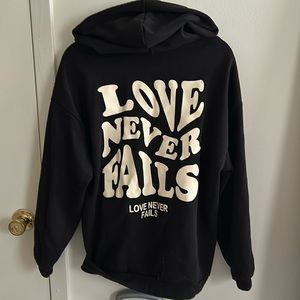 LOVE NEVER FAILS black hoodie